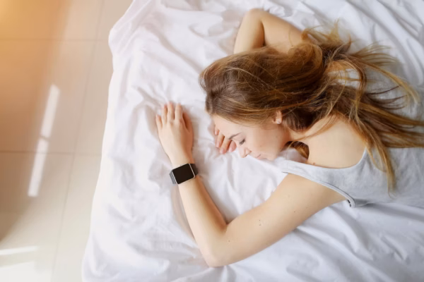 Young woman sleeping wearing smart watch