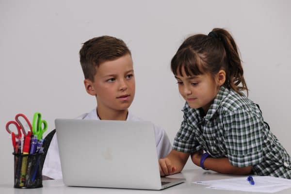 Learning and Epilepsy Boy and girl working on computer dressed in school uniform