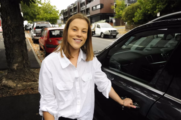 Young woman opening car door