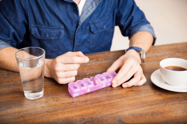 Man using daily medication dispenser