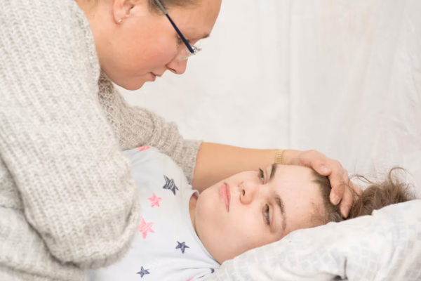 Mother leaning over to comfort girl in bed