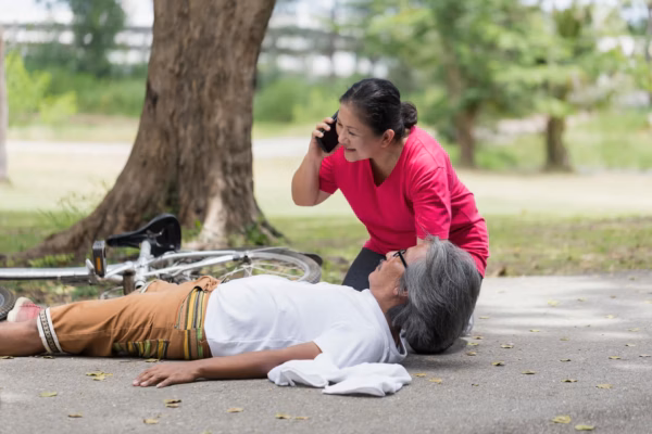 Woman helping man fallen on off bike