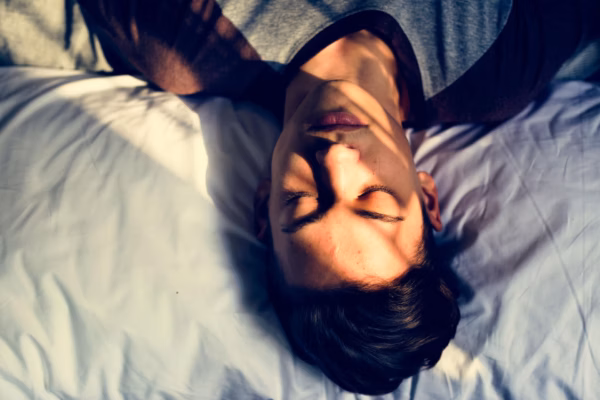 Young man asleep head on pillow