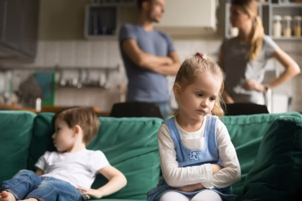 Young girl with blank stare sitting on couch