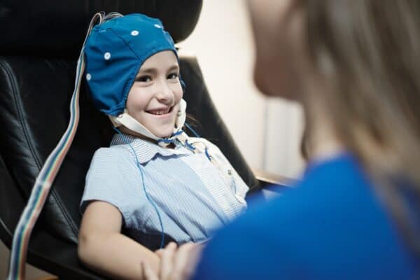 portrait-of-smiling-autistic-girl-undergoing-an-ee-EKRTJ2X
